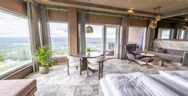 Naava Suite living and sleeping areas beside large windows overlooking the Iso-Syöte landscape